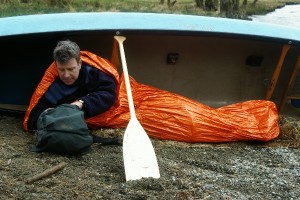 Blizzard Survival sleeping bag on lakeside at canoe trip portage.